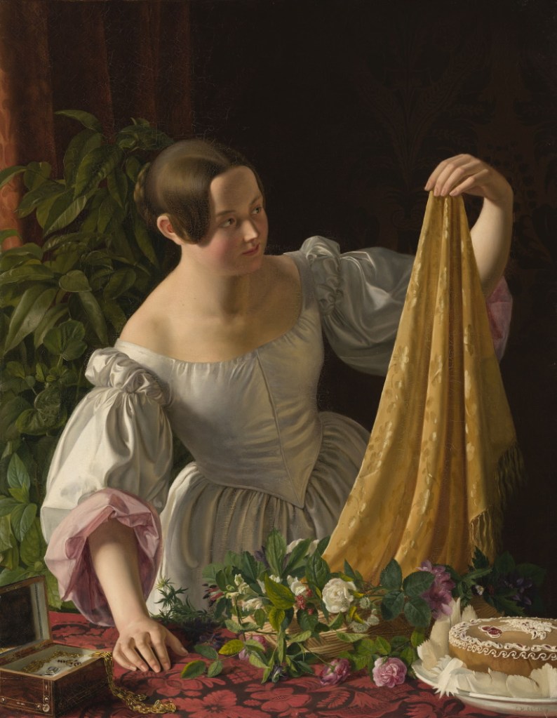 noor tütarlaps imetleb kingituseks saadud salli, laual uhke tort